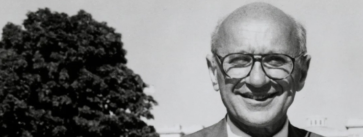 Detail of a black and white photograph of economist Milton Friedman with a tree in the background