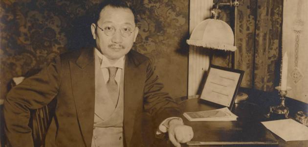 Sepia tone photograph of H. H. Kung seated at desk, 1930s