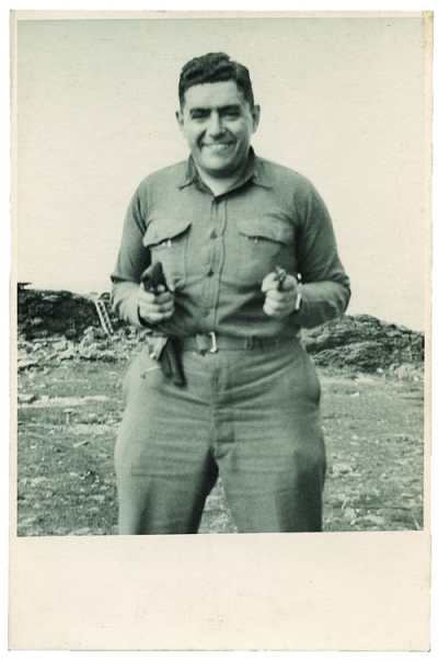 Brickman wearing Army fatigues and holding a pistol