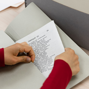 photo of hands holding archival document as it is removed from a folder