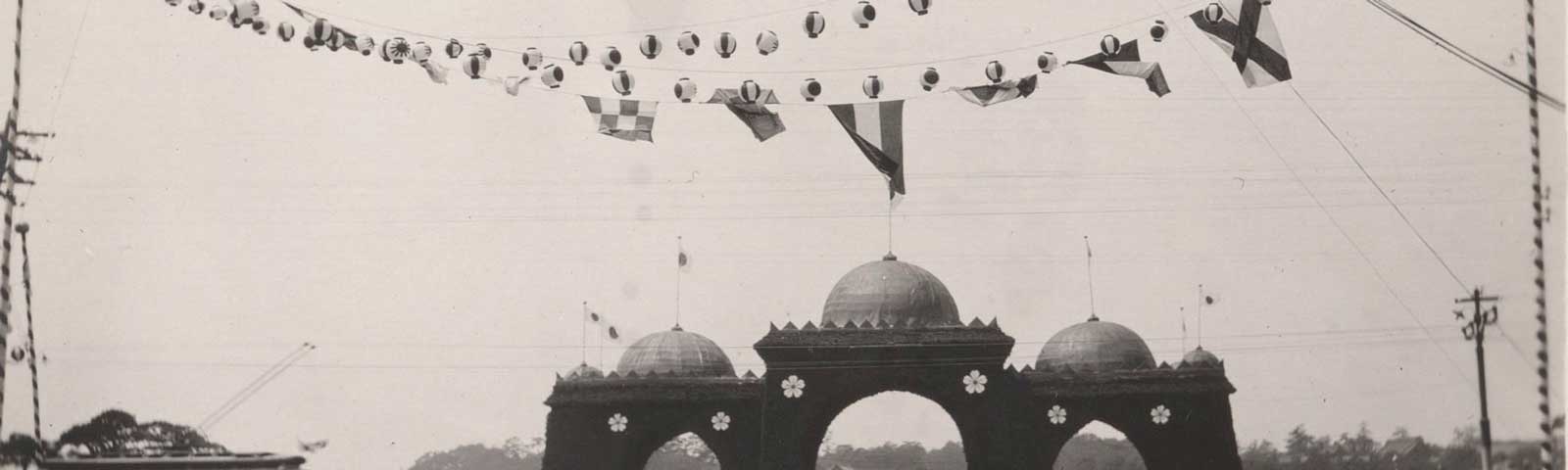 black and white photo of a building and flags and lanterns overhead