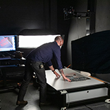 Photographer adjusting a poster for digitization under a camera