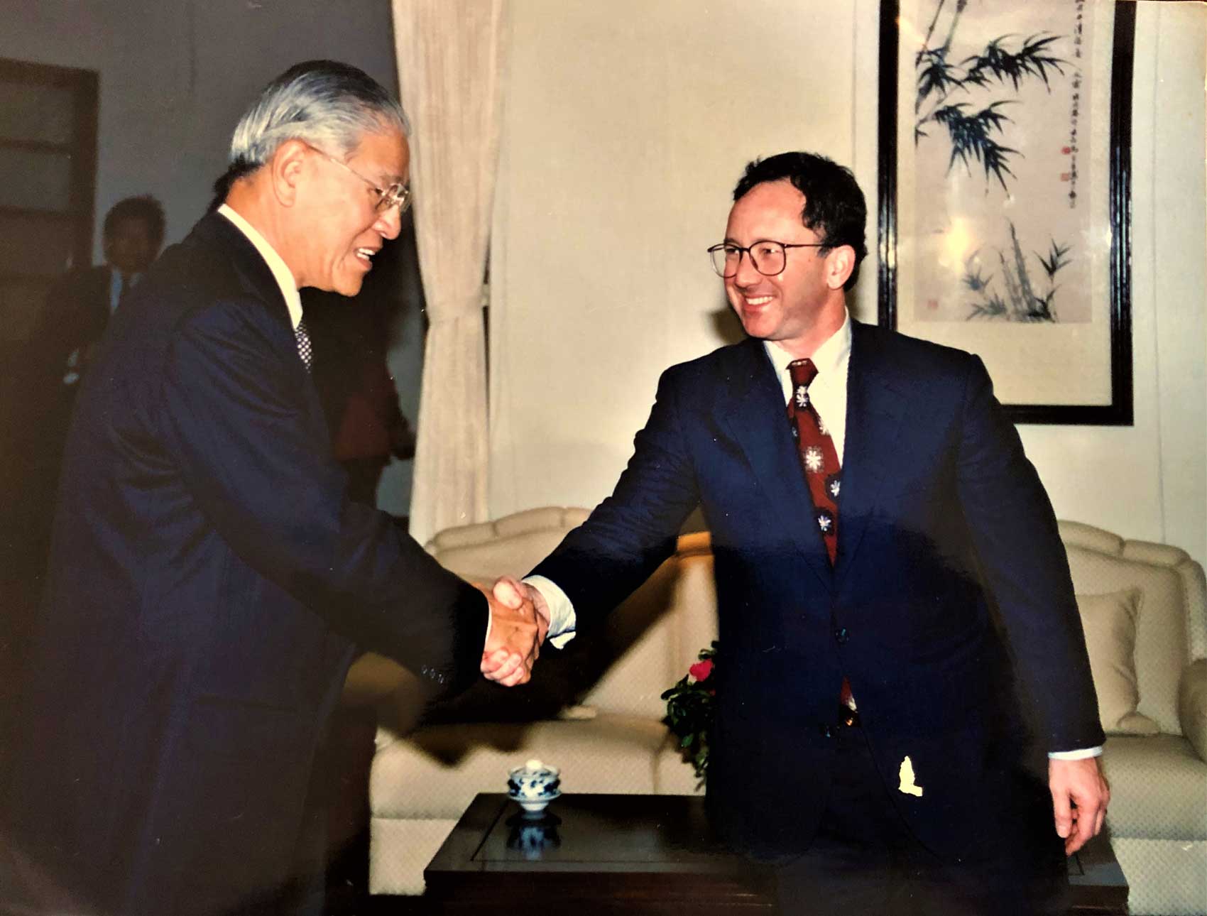 Two men wearing suits shaking hands