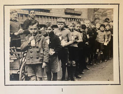 Group of children standing in line drinking from a bottle with a straw