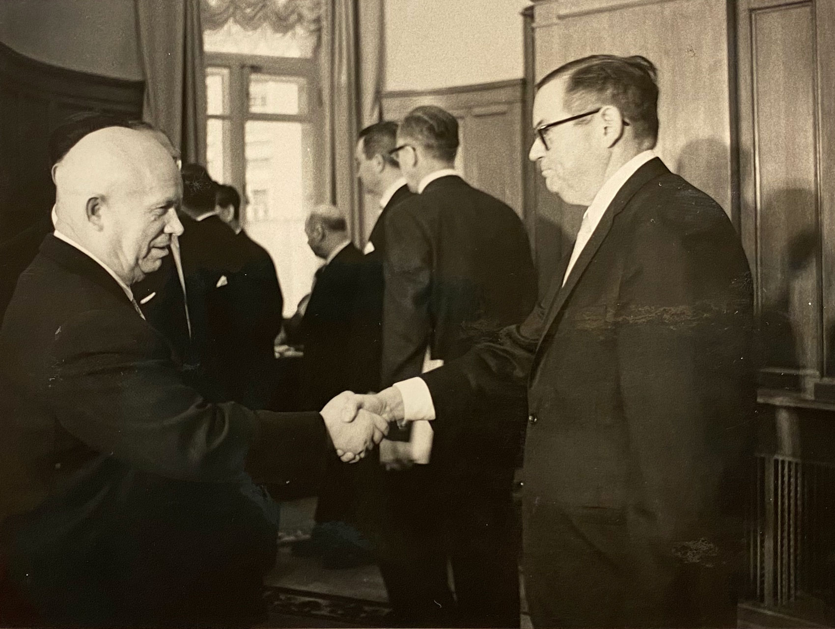 Black and white photo of 2 men shaking hands. Khruschev shaking hands with TIME news tour participant in 1963