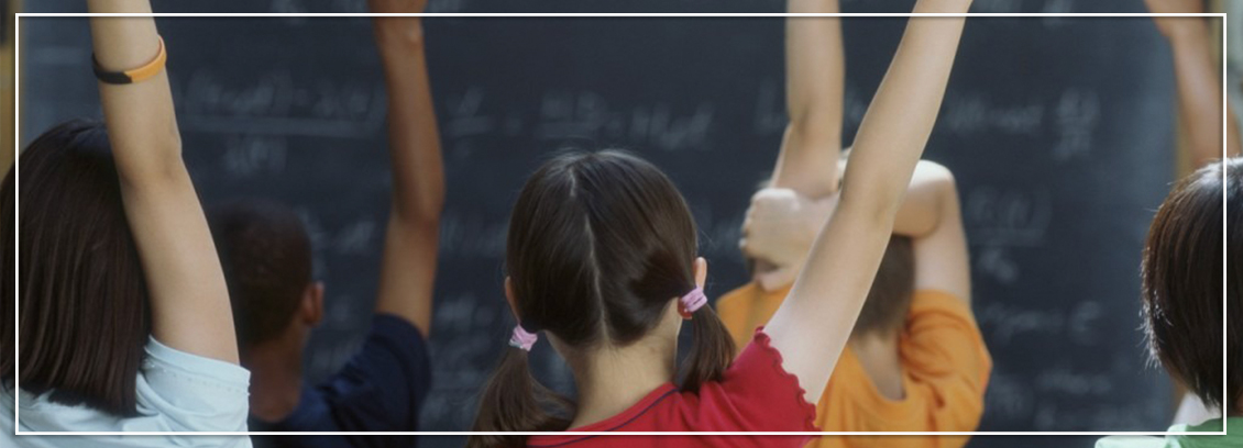 Students in a classroom raising their hands