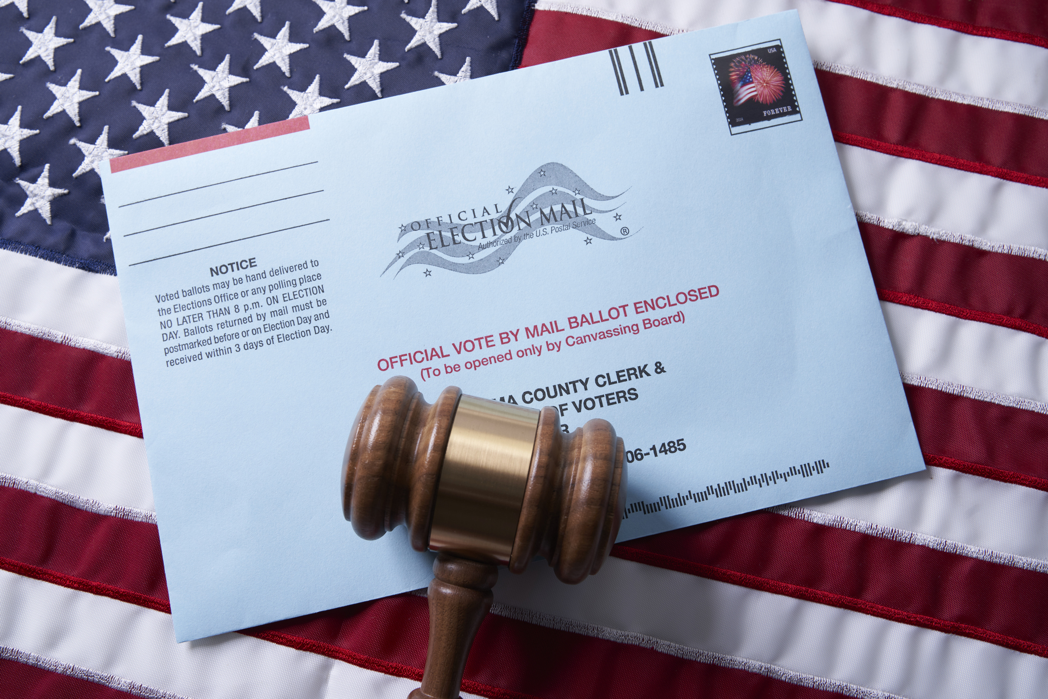 Voting ballot: Absentee voting by mail with ballot envelope on USA flag and gavel stock photo
