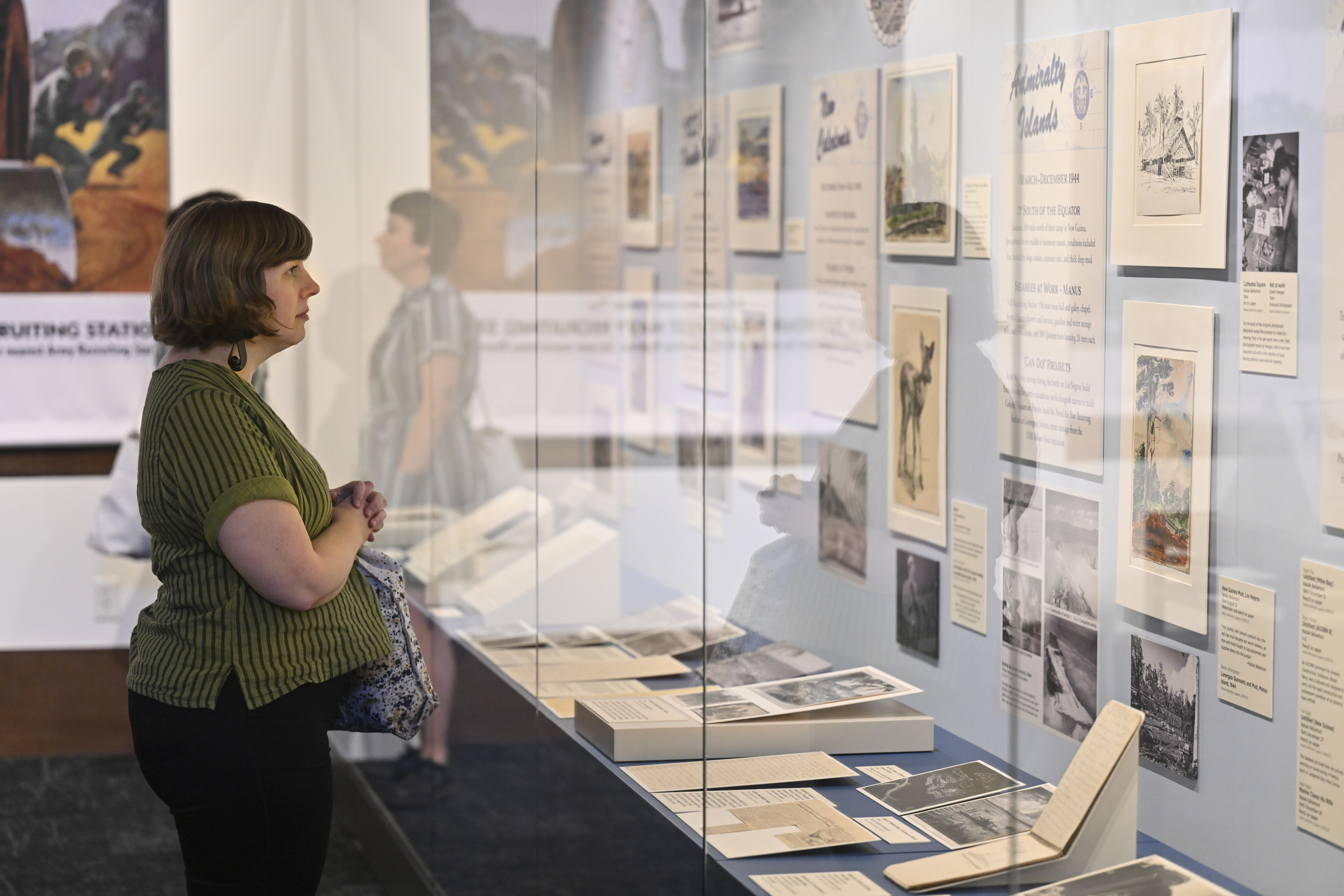 Archivist viewing The Battalion Artist exhibition cases