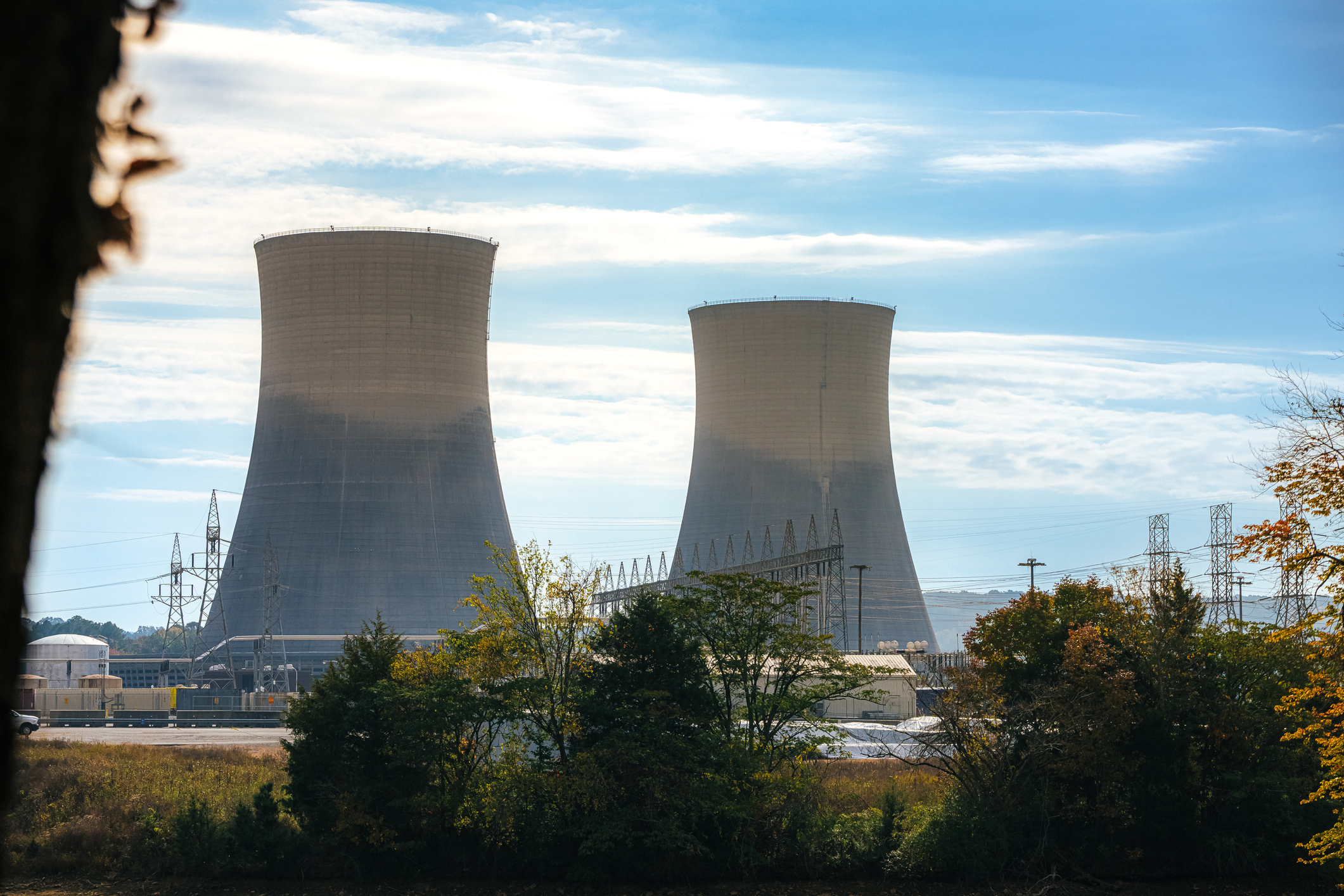 Green Trees surrounding the tall Cooling Towers of a Nuclear Power Plant in Tennessee on a Sunny Autumn Day stock photo