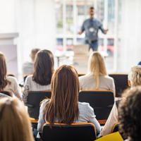 Rear view of business people attending a seminar in board room. stock photo