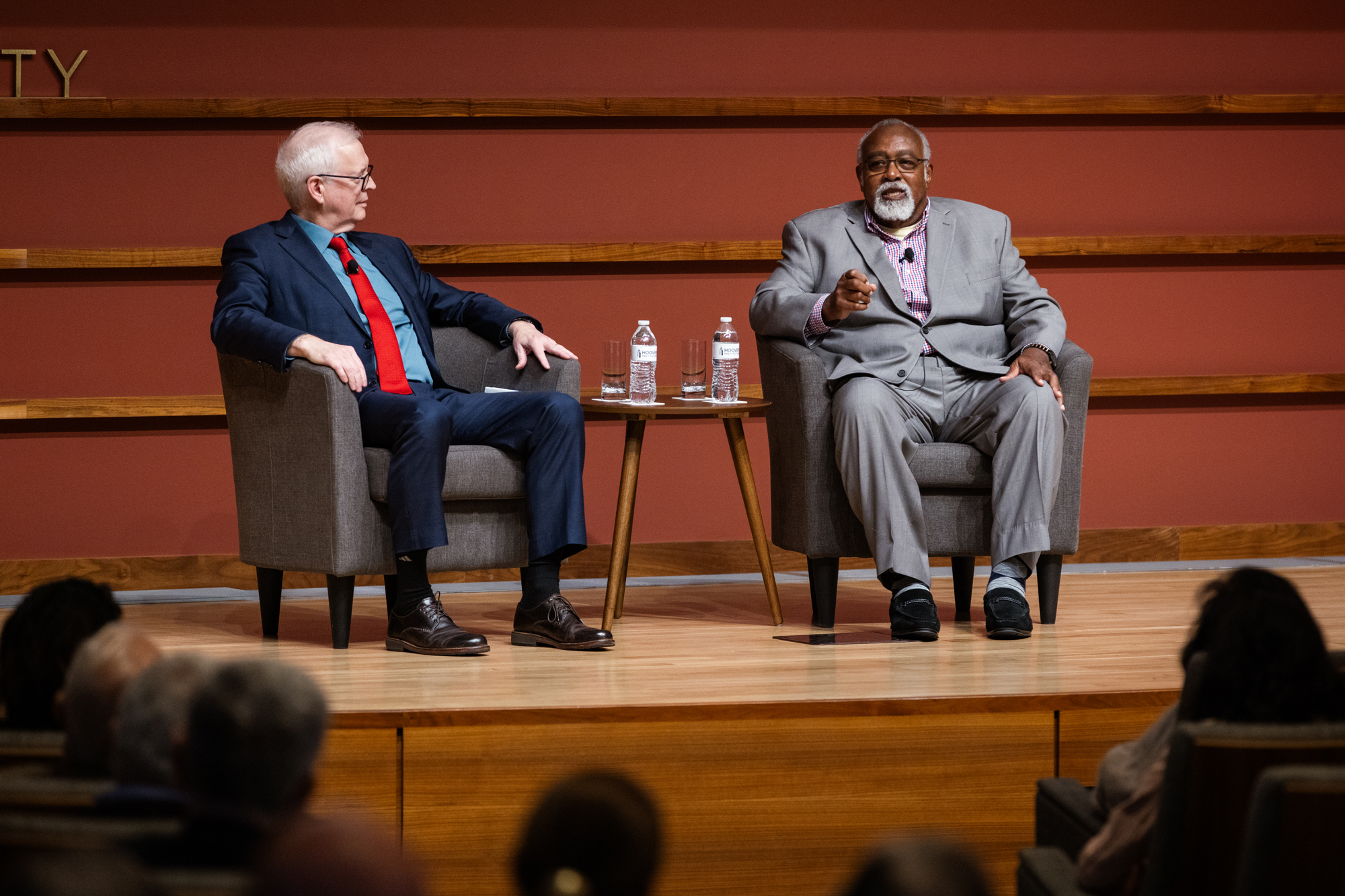Steven Davis and Glenn Loury are seen on stage in Hoover’s Hauck Auditorium on October 10, 2025. (Patrick Beaudouin)