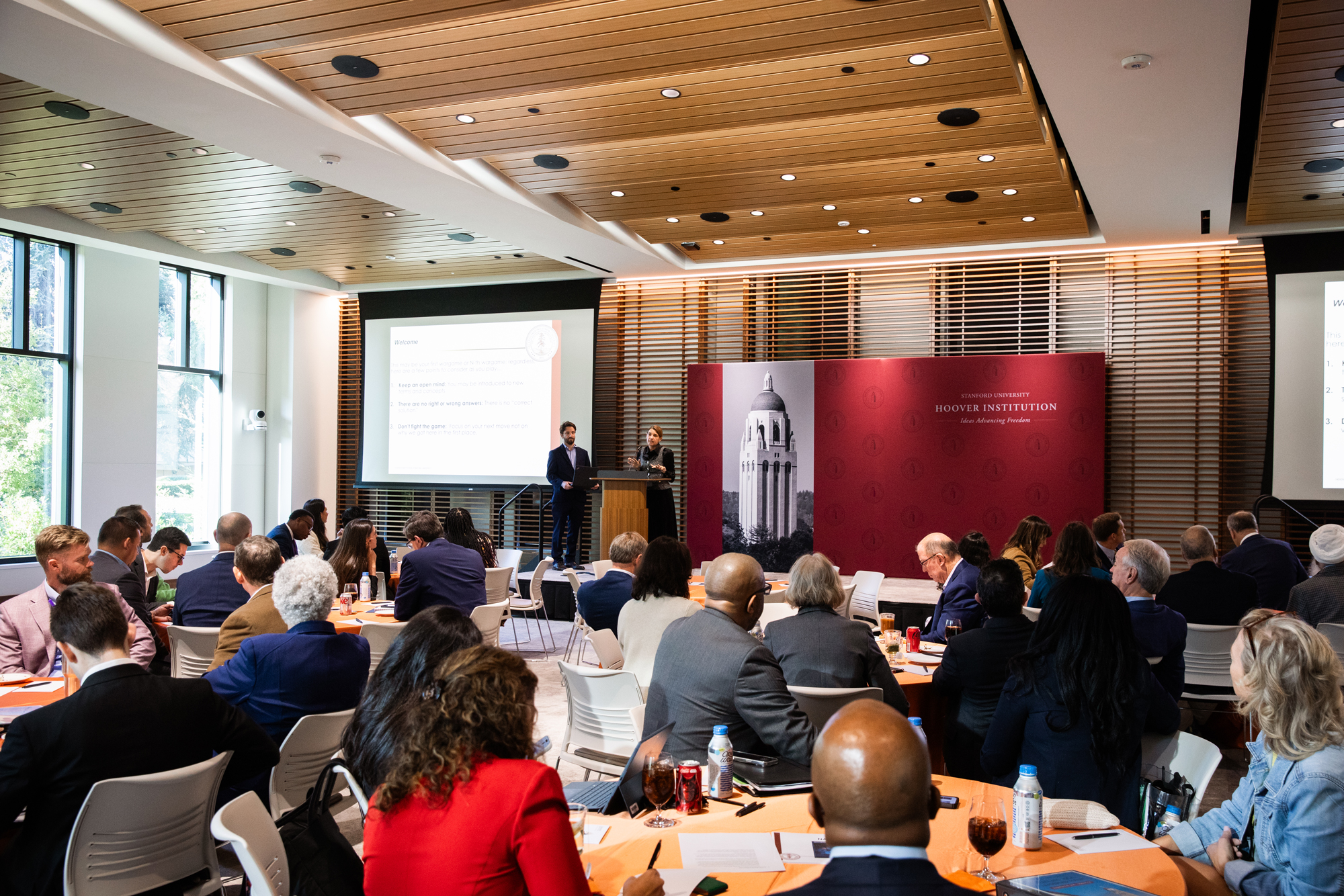 Hoover Fellow Jacquelyn Schneider and Program Manager Jacob Ganz from the Wargaming and Crisis Simulation Initiative walk participants through a tabletop exercise in Shultz Auditorium. (Patrick Beaudouin)