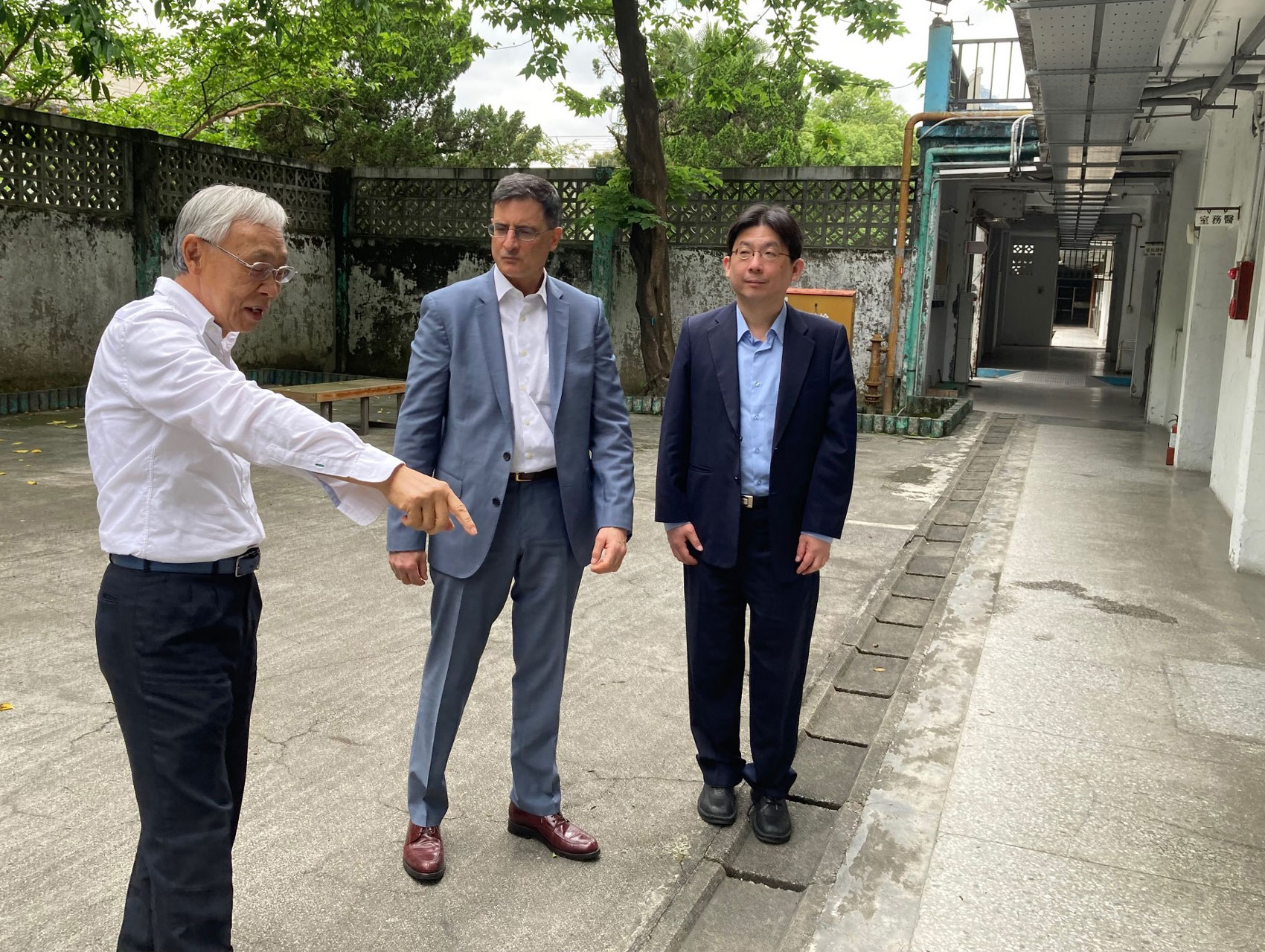 Three men standing, visiting White Terror Memorial Park