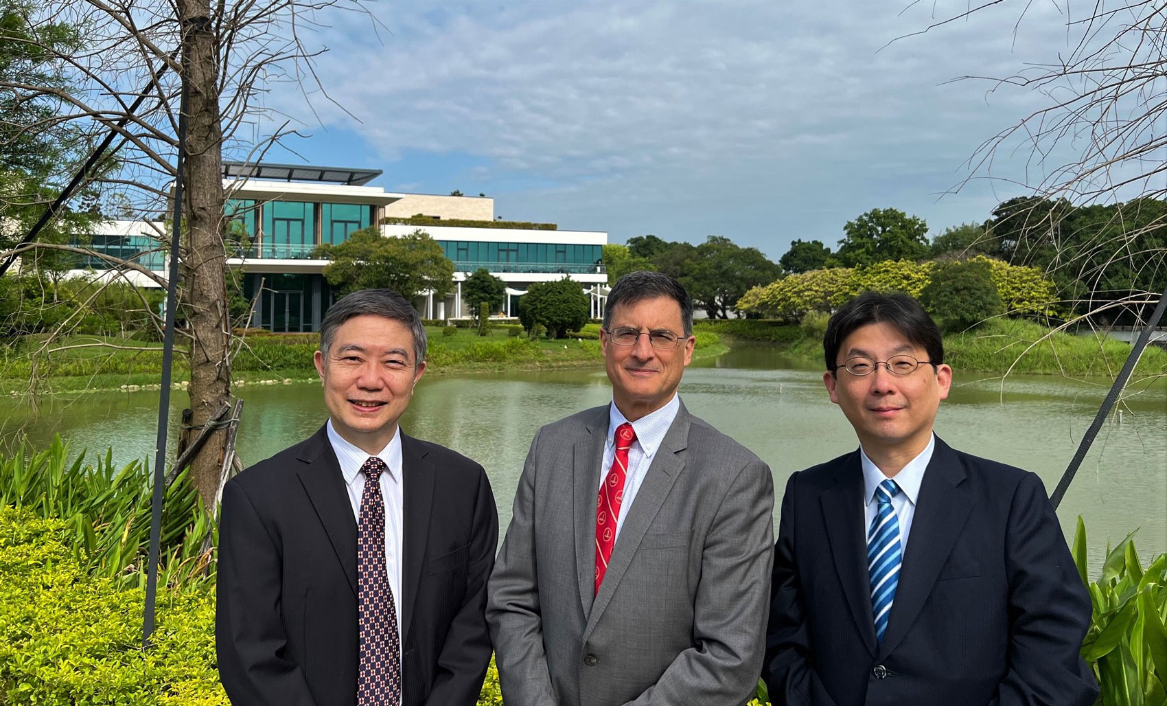 Three men standing in front of a building