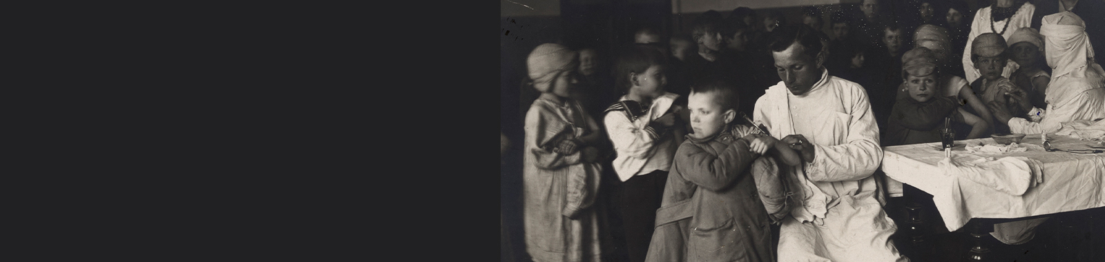 Black and white photograph of ARA staff administering vaccines to children in 1922 Petrograd.