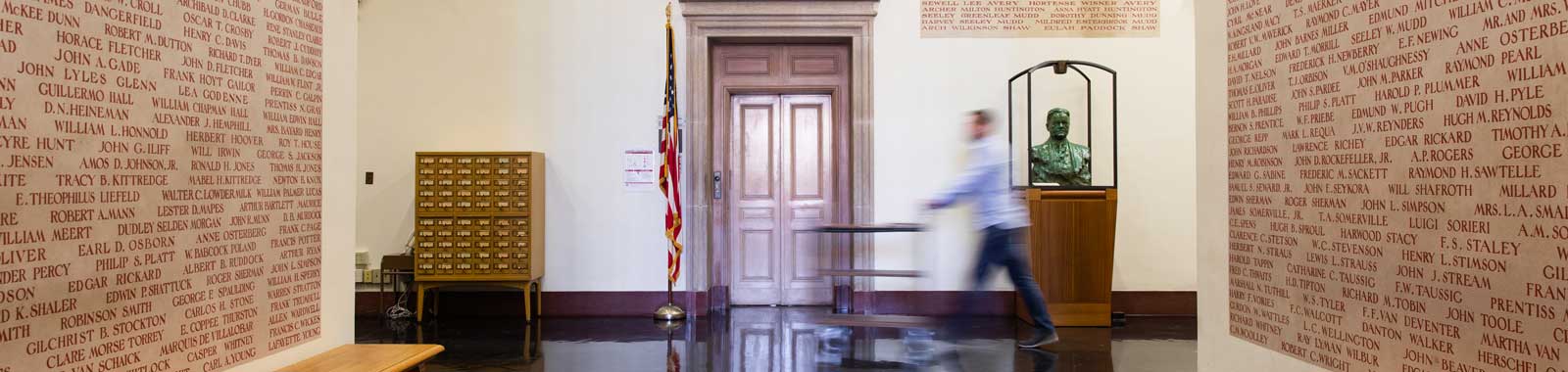 Librarian pushes a cart in the lobby of Hoover Tower