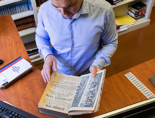 Hoover librarian cataloging a book at their desk 