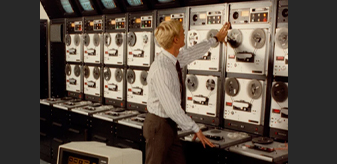 Detail of color photo showing a man standing in front of radio soundboard, From the RFE/RL Corporate Records, 2000C71.197