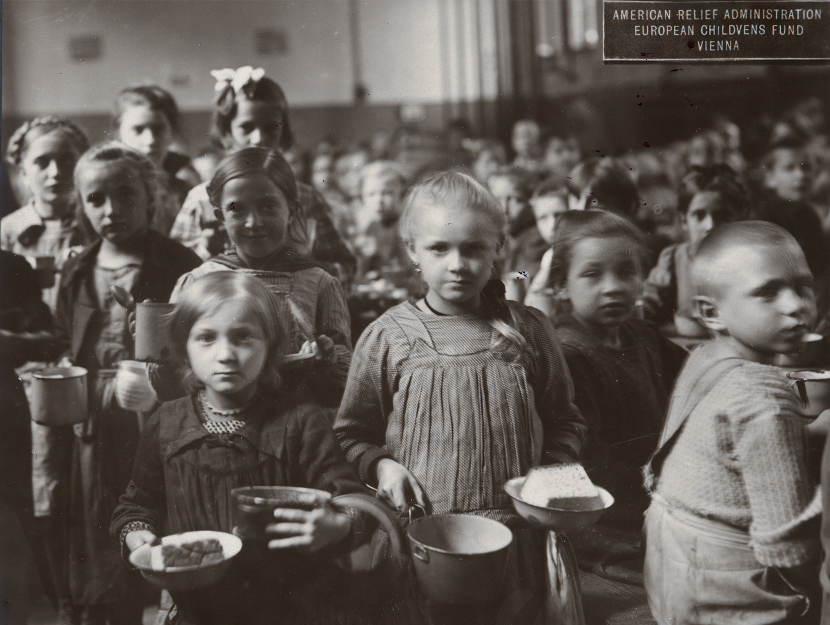 Black and white photograph of children in an ARA kitchen, Vienna, circa 1919.