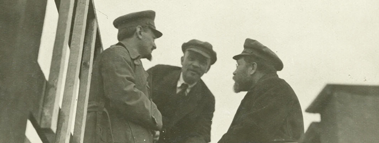 detail of a sepia tone photograph showing three leaders of the early communist movement in Russia, including Trotsky and Lenin