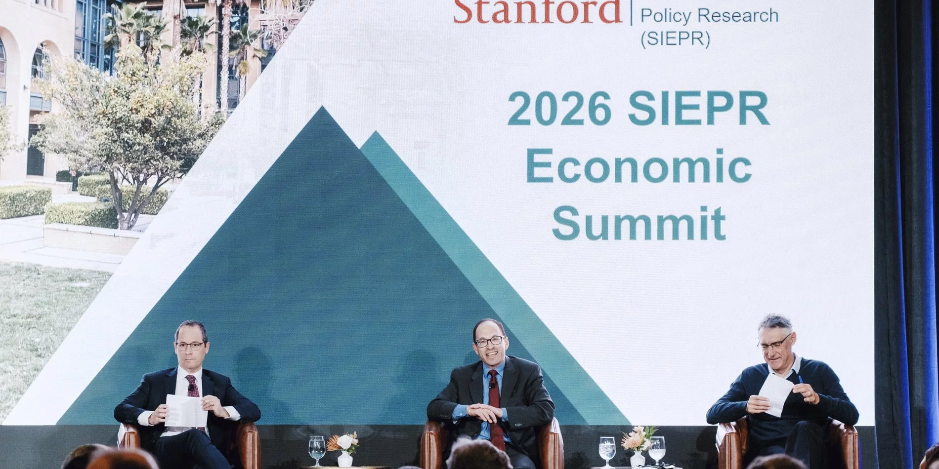 At the 2026 SIEPR Economic Summit, Stanford's Josh Rauh and UC Berkeley's Emmanuel Saez debate the proposed California wealth tax, in a session moderated by the Wall Street Journal's Richard Rubin. (Photo credit: SIEPR)