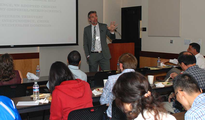 Pierre Asselin standing in front of a room full of people