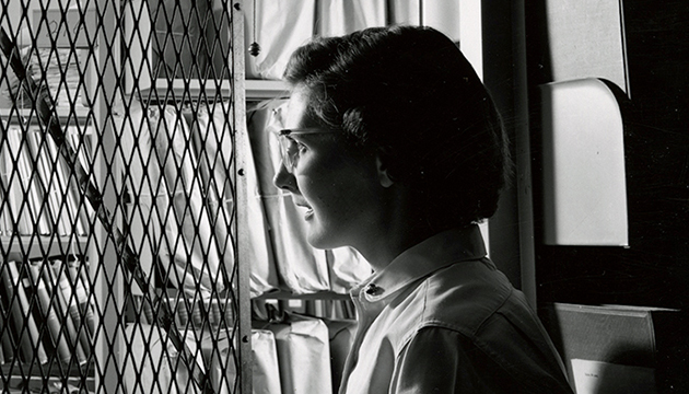 Black and white photograph of woman entering the archives stacks inside Hoover Tower