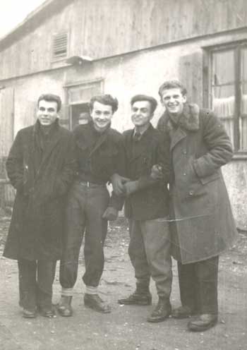 black and white photo of 4 men in standing in front of a building