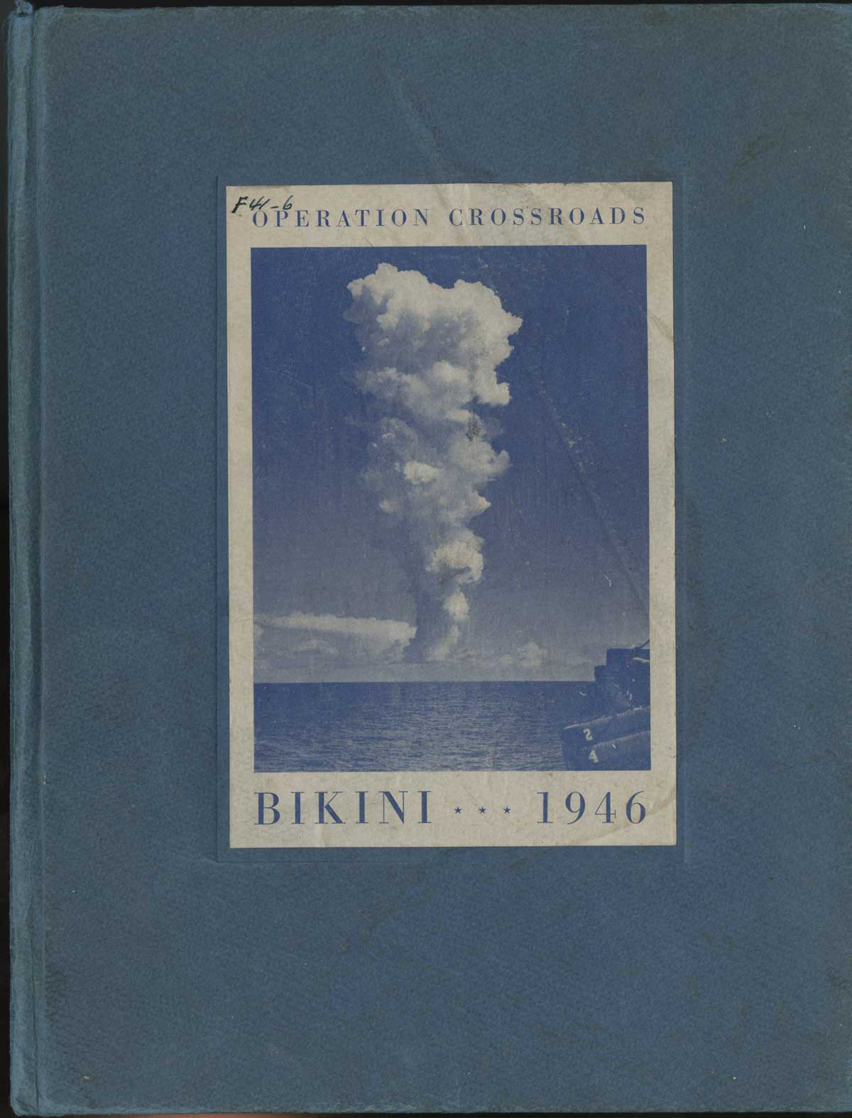 Blue book cover with title "Operation Crossroads Bikini 1946" and photo of bomb cloud on a white label