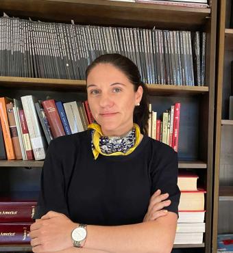 Katharina Friedla standing in front of book case