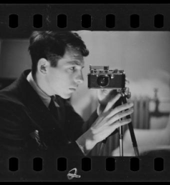 Buchman taking a self-portrait with his camera. Digitized black and white photo negative.