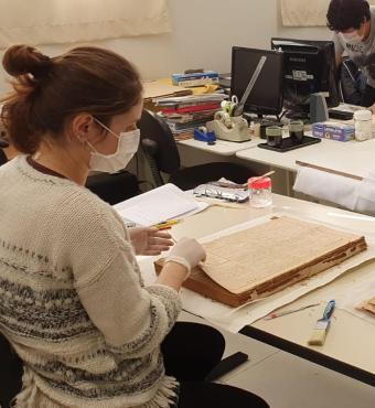 Conservators at Historical Museum of Japanese Immigration working on Burajiru Jiho newspapers