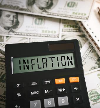 Calculator stating inflation with money in the background