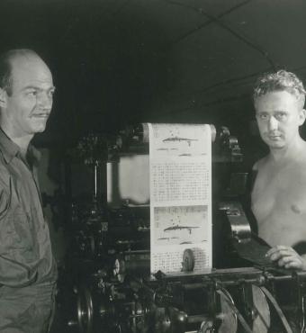 Two men operating a print press at the Office of War Information