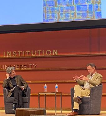 Alex de Waal and Niall Ferguson sitting on the stage of Hauck Auditorium