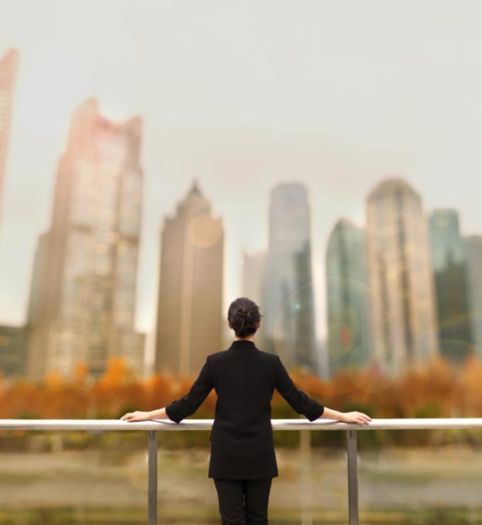 Young woman standing with view of buildings in city downtown