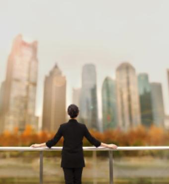 Young woman standing with view of buildings in city downtown