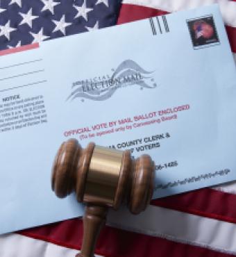 Voting ballot: Absentee voting by mail with ballot envelope on USA flag and gavel stock photo