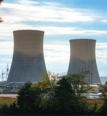 Green Trees surrounding the tall Cooling Towers of a Nuclear Power Plant in Tennessee on a Sunny Autumn Day stock photo