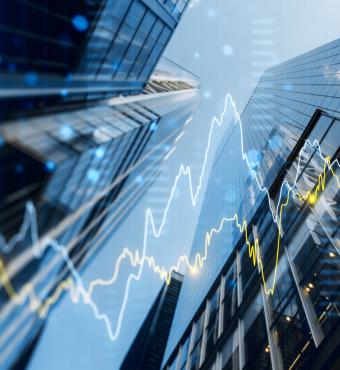 A double exposure image of skyscrapers with overlay of financial graphs, set against a blurred background, illustrating the concept of business growth stock photo