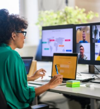 Woman discussing report with remote workers stock photo