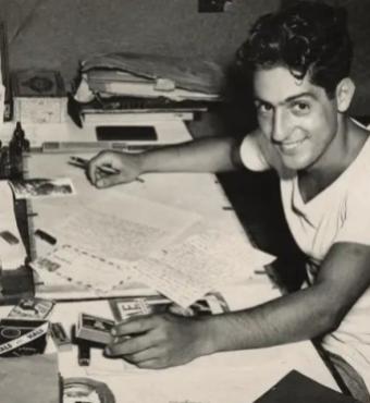 Nat Bellantoni writting a letter at his desk in a tent during World War II