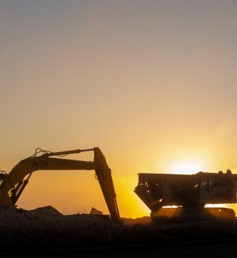 Construction machinery in the rays of the rising sun, early morning at the construction site stock photo