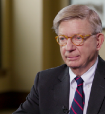 Image of George F. Will sitting at a table.