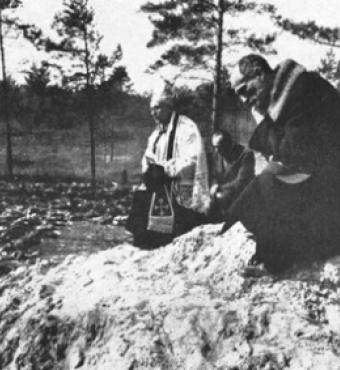 Father Stanislaw Jasinski, representative of the bishop of Krakow, prays over the mass graves