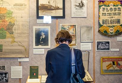 Color photograph of a woman standing in front of a past exhibition display at Hoover
