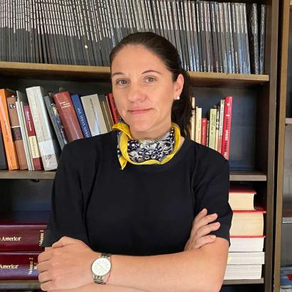 Katharina Friedla standing in front of book case