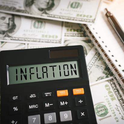 Calculator stating inflation with money in the background