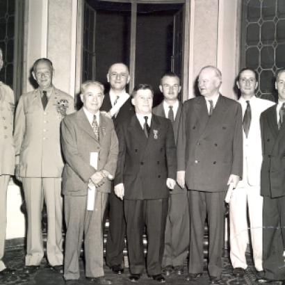 Group of men standing for a photo. Nicholas Feodoroff (front row center) with Herbert Hoover (front row right).
