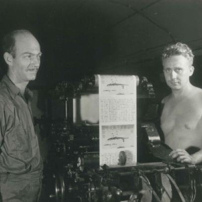 Two men operating a print press at the Office of War Information
